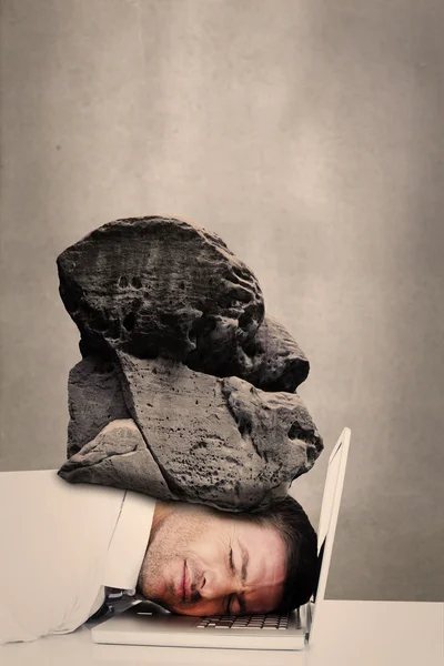 Businessman sleeping with stone on head