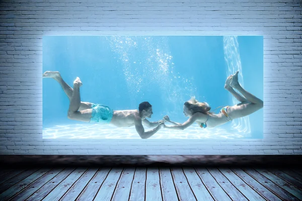 Couple holding hands underwater