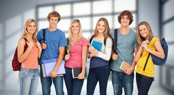 Students wearing backpacks and holding books