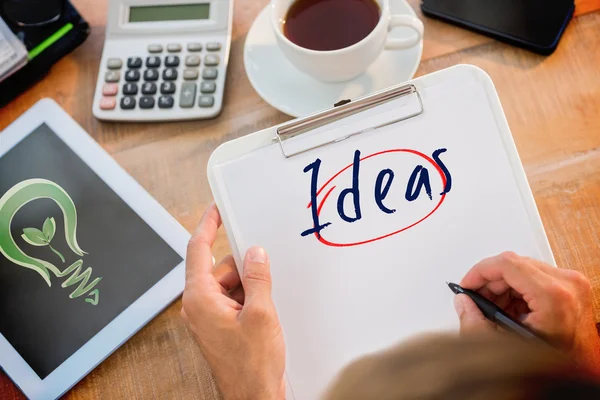 Man writing on clipboard on working desk