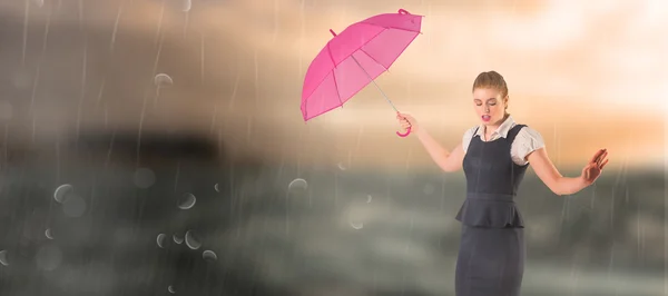 Pretty redhead businesswoman holding umbrella