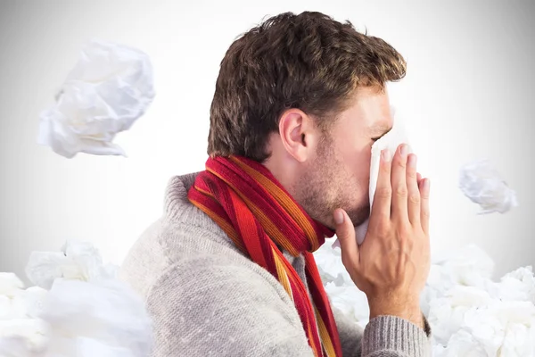 Man blowing nose on tissue