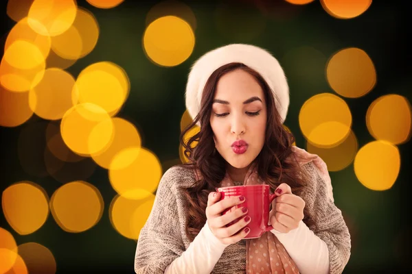 Brunette in winter clothes holding hot drink