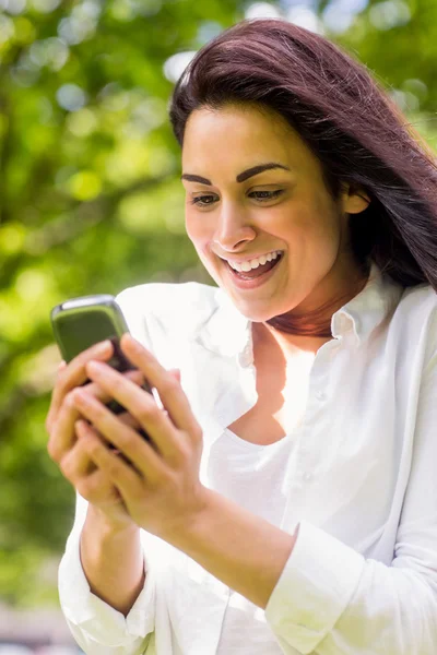 Brunette in the park sending text