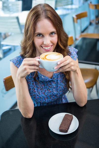 Brunette having coffee and cake