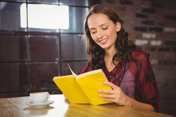 Smiling brunette turning the page