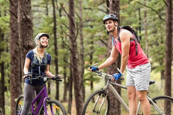 Couple on bikes looking away