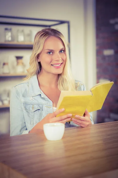 Smiling blonde holding yellow book