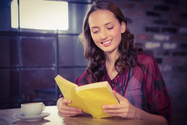 Brunette reading yellow book