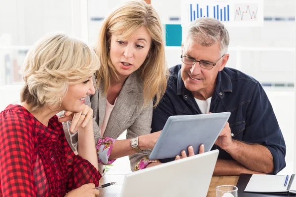 Business team discussing over a tablet