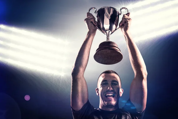 Rugby player holding trophy