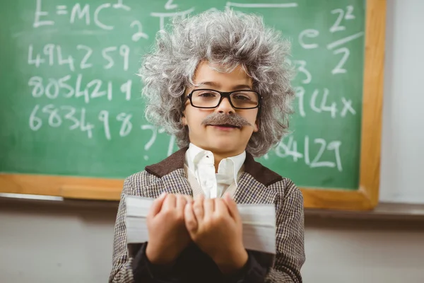 Little Einstein holding books in front of chalkboard