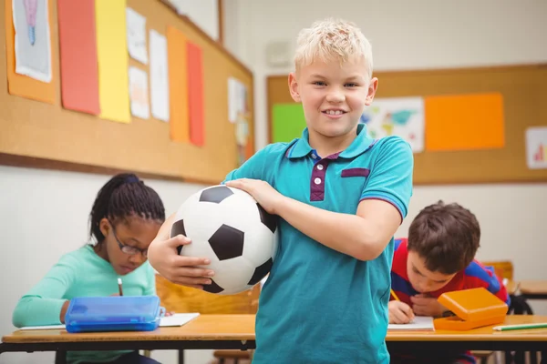 Smiling student holding a football
