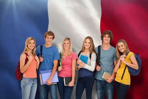 Smiling students wearing backpacks and holding books