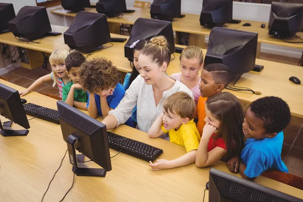 Teacher showing students how to use computer