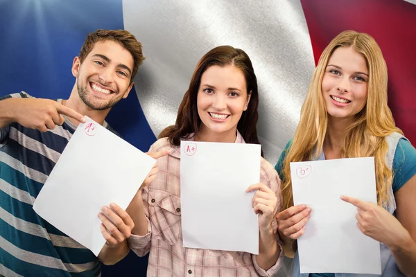 Smiling students showing their exams