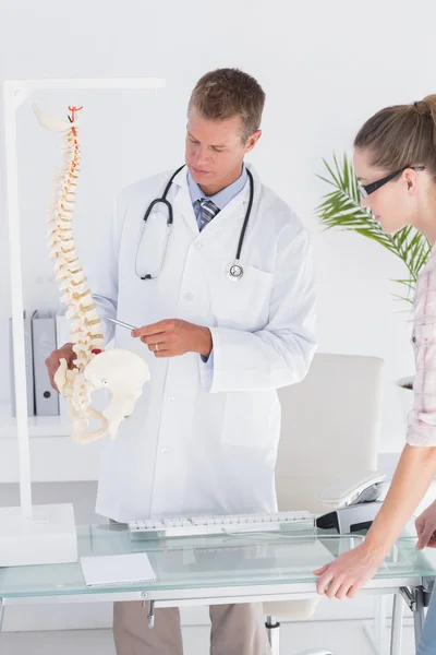 Doctor explaining anatomical spine to patient