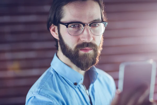 Confident hipster looking at cellphone