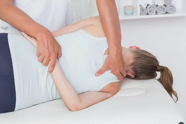 Doctor stretching a woman back