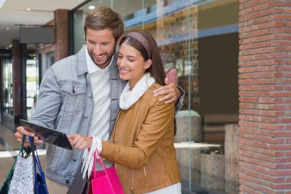 Couple looking at tablet in front of store