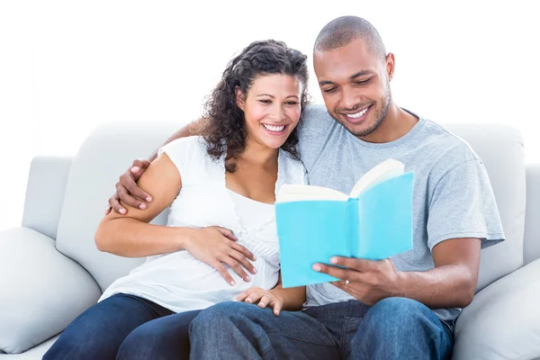 Couple reading book relaxing at home