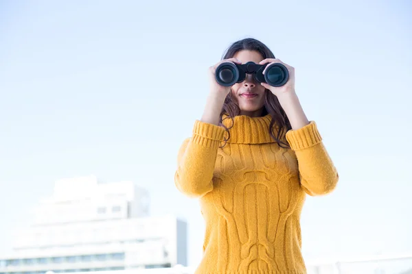 Beautiful woman looking through binoculars