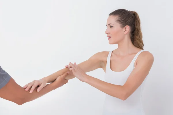 Doctor stretching woman arm