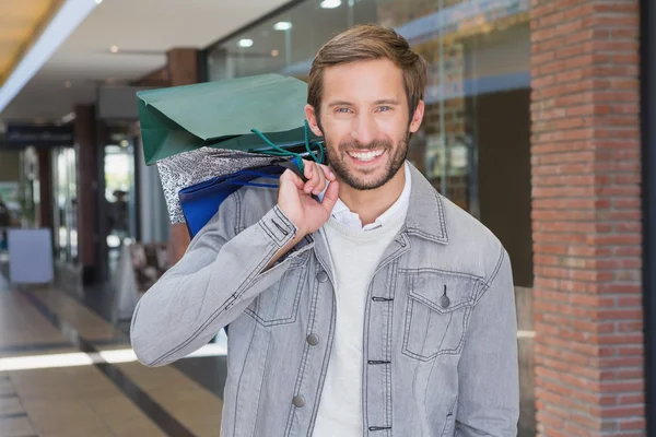 Smiling man holding shopping bags