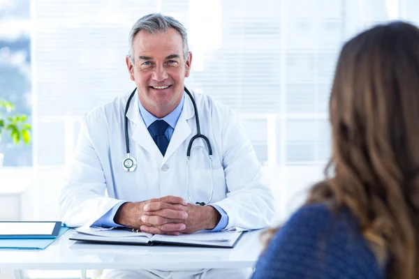 Male doctor sitting with woman