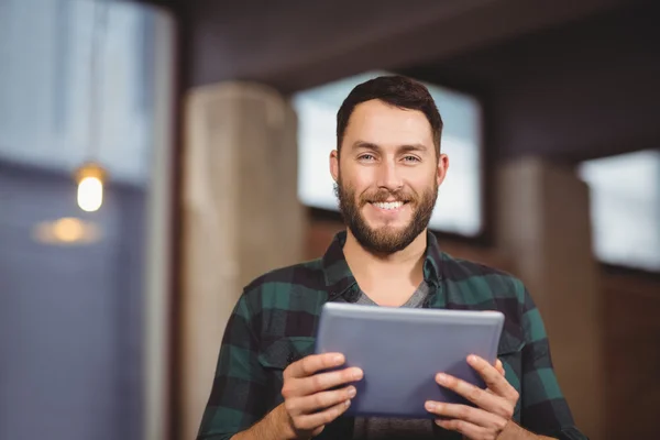 Cheerful businessman holding tablet