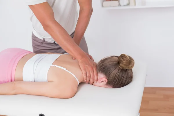 Physiotherapist doing neck massage to patient