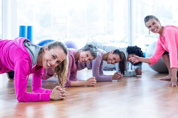 Portrait of smiling group of women exercising on floor
