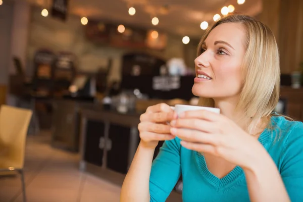 Young woman holding coffee cup looking away