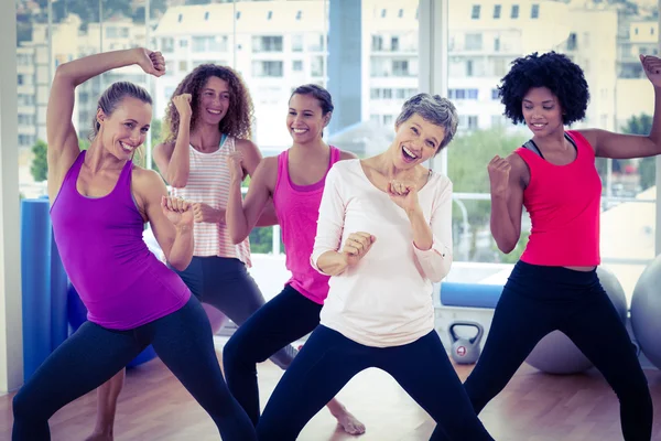 Portrait of happy women exercising with clasped hands
