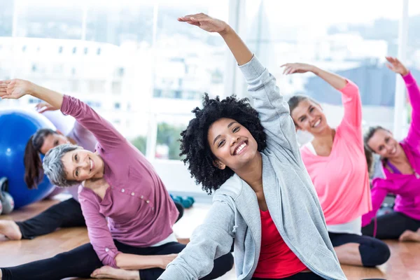 Cheerful women exercising with arms raised