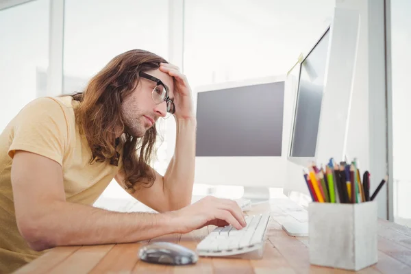 Frustrated hipster working on computer