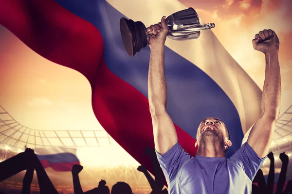 Happy rugby player holding trophy