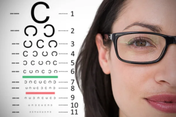 Brunette wearing eye glasses against eye test