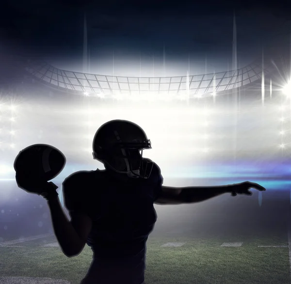 Silhouette of American football player throwing ball