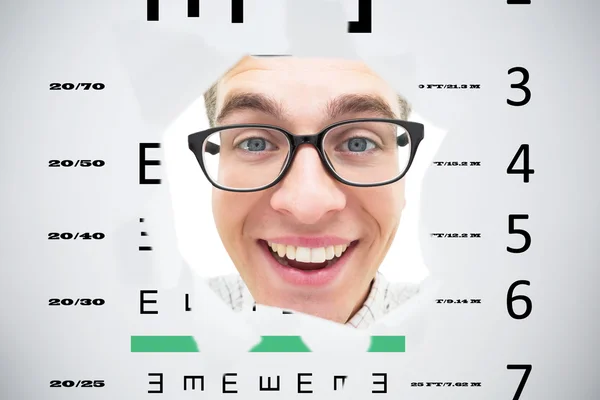 Geeky hipster smiling through hole against eye test