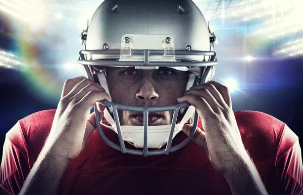 American football player holding helmet