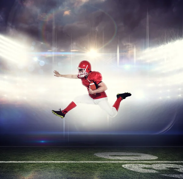 American football player jumping with the ball