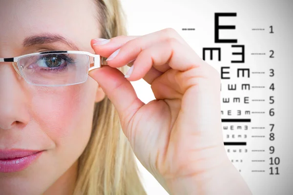 Pretty blonde with reading glasses against eye test