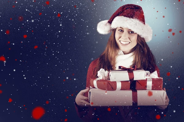 Festive redhead holding pile of gifts