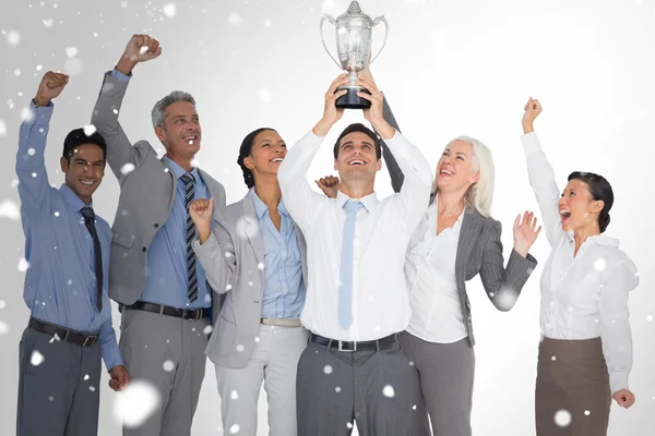 Business people holding cup and cheering
