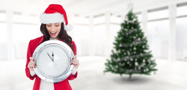 Excited brunette holding a clock