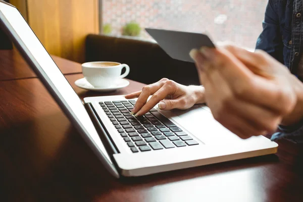 Student using laptop in cafe to shop online