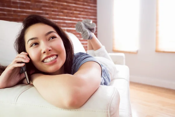 Asian woman calling on couch