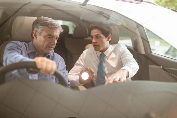 Businessman pointing a car interior