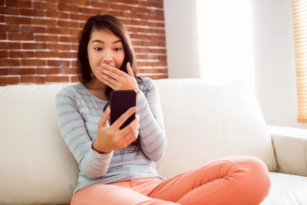 Asian woman reading shocking text